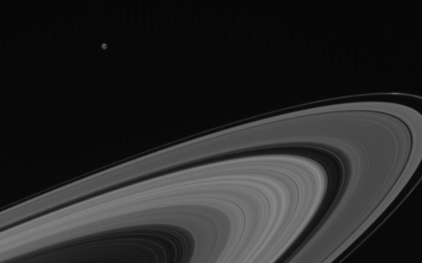 Удивительное фото: спутник Сатурна Тетис сияет над его кольцами